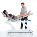 Fizjoterapeuta prowadzący terapię kończyn dolnych na stole Gymna.PRO Q.