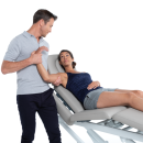 Terapeuta wykonujący mobilizację stawu barkowego pacjentce leżącej na stole Gymna.PRO Q.