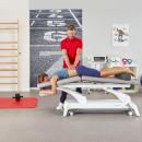 Fizjoterapeuta wykonujący masaż pleców pacjentowi na stole Gymna.PRO w gabinecie rehabilitacji.