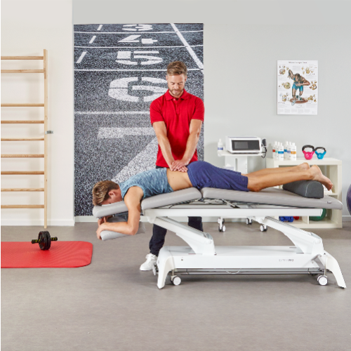 Fizjoterapeuta wykonujący masaż pleców pacjentowi na stole Gymna.PRO w gabinecie rehabilitacji.