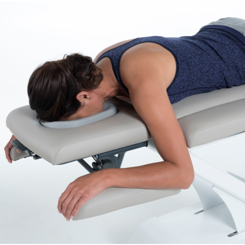 Pacjentka leżąca twarzą w dół na stole Gymna.PRO z podparciem głowy i ramion.