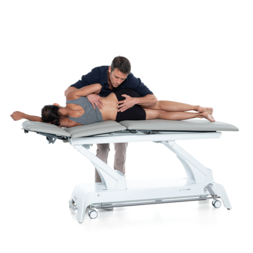 Terapeuta wykonujący technikę mobilizacji odcinka lędźwiowego na stole Gymna.PRO.